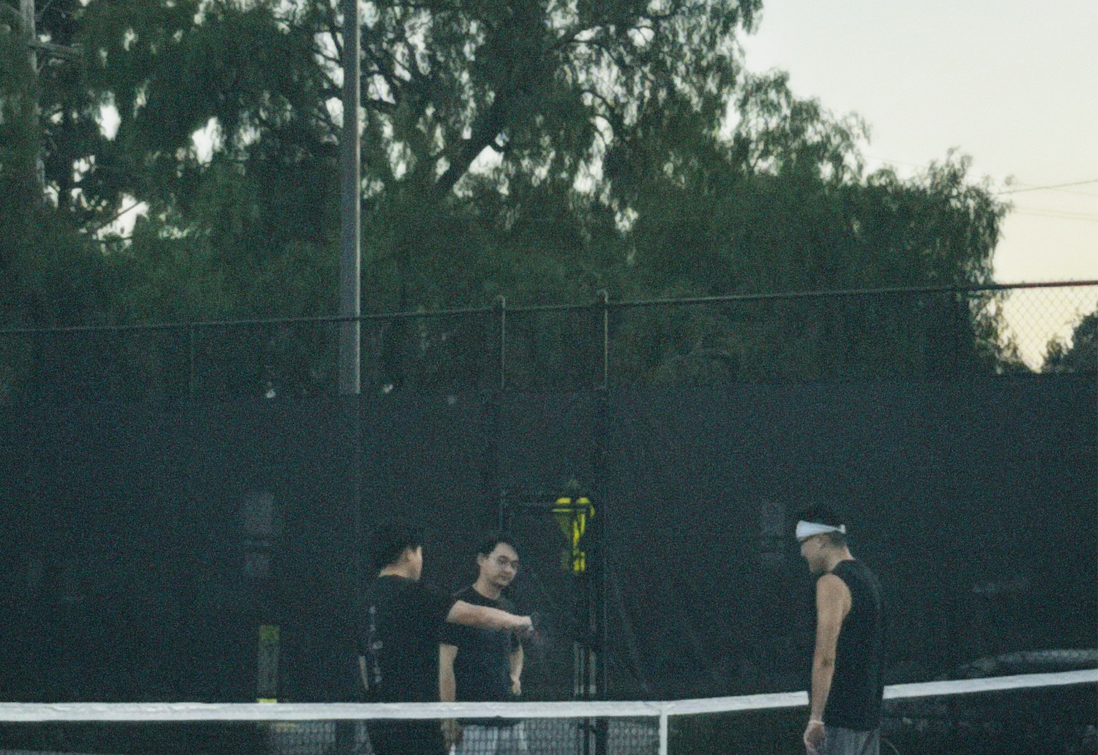Coach speaking with athletes at a pickleball court